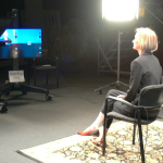 Talent preparing for scripted delivery in lit studio